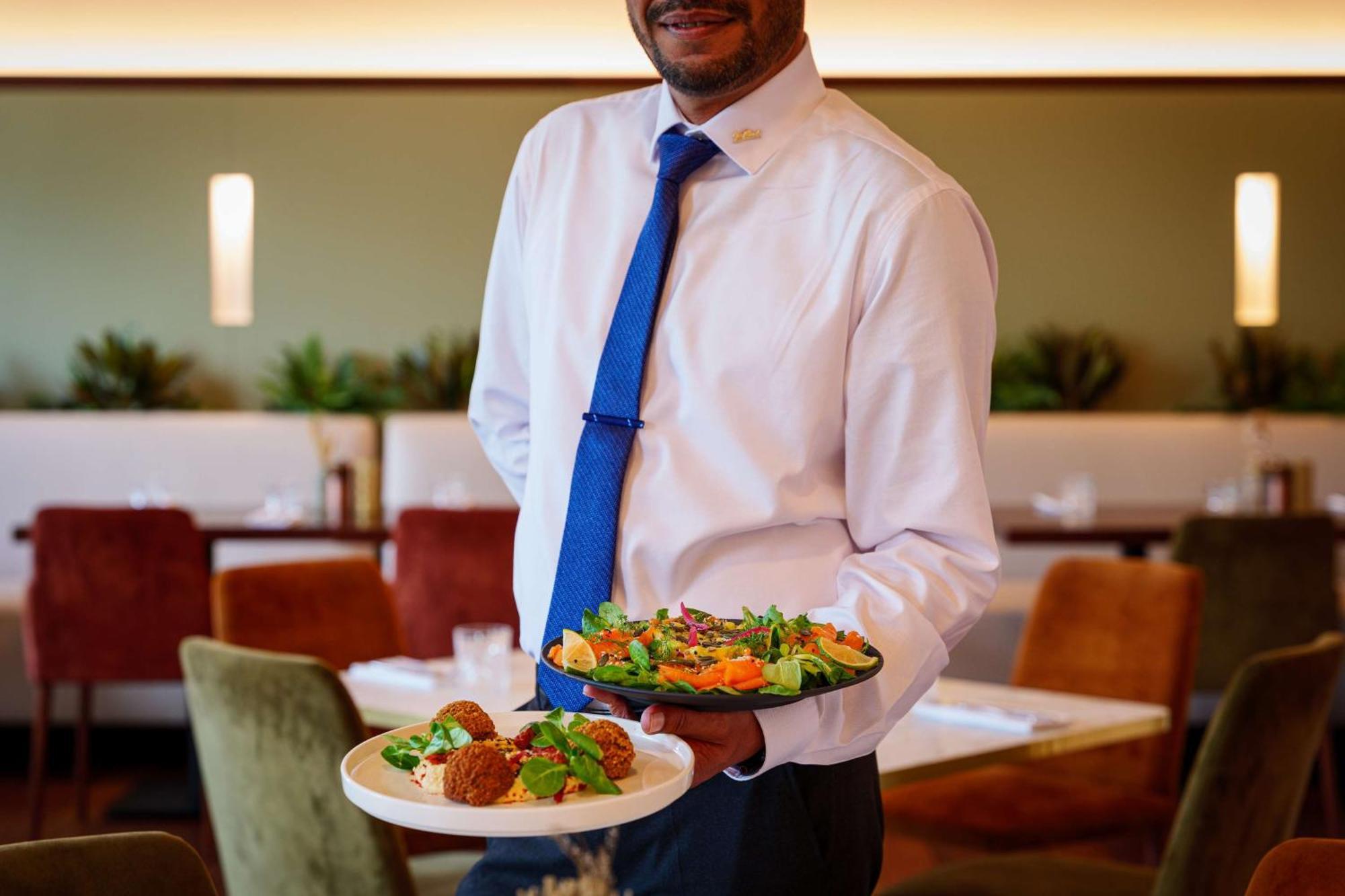 Radisson Blu Hotel Paris, Marne-la-Vallée Magny-le-Hongre Esterno foto Waiter holding plate of food